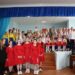 Alt: "Групове фото учасників святкового концерту в актовій залі: діти та молодь у сценічних костюмах