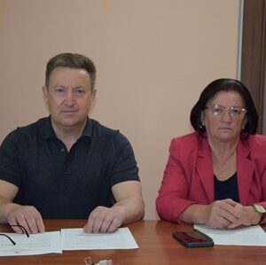 alt="На фото зображені два представники, що сидять за столом під час офіційної зустрічі або засідання"