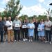 alt="Група представників Городоцької громади під час передачі квадрокоптерів для Збройних Сил України. Люди тримають у руках коробки з дронами та самі квадрокоптери. Знімок зроблений на вулиці біля адміністративної будівлі, на тлі дерев та ясного неба."