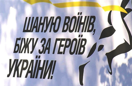 alt="Банер із надписом "Шаную воїнів, біжу за Героїв України!" на фоні неба та абстрактного зображення фігури бігуна."