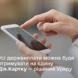 На зображенні — чоловічі руки, що тримають смартфон. На фоні — розмитий нейтральний інтер'єр. У нижній частині зображено текст: «Усі держвиплати можна буде отримувати на єдину Дія.Картку — рішення Уряду»