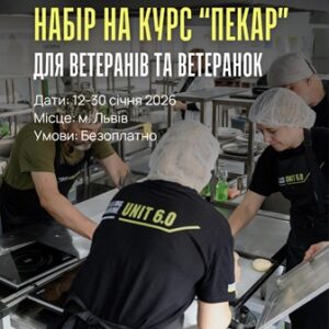 На фото кілька людей у кухонному приміщенні під час навчання пекарській справі. Вони працюють у фірмових чорних фартухах із написом “UNIT 6.0” і в одноразових шапочках.