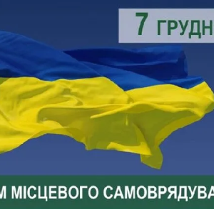 На фото зображено великий український прапор, що майорить на вітрі на фоні чистого синього неба. У верхньому правому куті розміщено напис «7 грудня» у зеленому та сірому кольорах. Унизу — зелена смуга з білим текстом: «З ДНЕМ МІСЦЕВОГО САМОВРЯДУВАННЯ!». В лівому верхньому куті також видно малий тризуб.