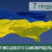 На фото зображено великий український прапор, що майорить на вітрі на фоні чистого синього неба. У верхньому правому куті розміщено напис «7 грудня» у зеленому та сірому кольорах. Унизу — зелена смуга з білим текстом: «З ДНЕМ МІСЦЕВОГО САМОВРЯДУВАННЯ!». В лівому верхньому куті також видно малий тризуб.