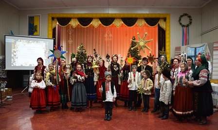 Групове фото учасників фестивалю колядок та щедрівок «Городок наш колядує» на сцені будинку культури: діти й дорослі у традиційних українських народних костюмах