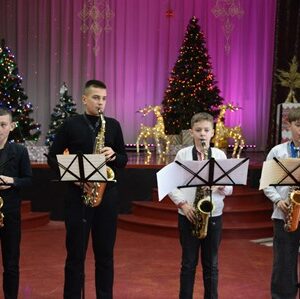 Учні Городоцької школи мистецтв виступають на сцені Будинку культури, виконуючи музичний номер на саксофонах під час новорічного концерту «Чарівні ноти Різдва»