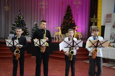Учні Городоцької школи мистецтв виступають на сцені Будинку культури, виконуючи музичний номер на саксофонах під час новорічного концерту «Чарівні ноти Різдва»