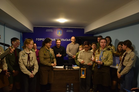 У залі засідань Городоцької сільської ради зібралися пластуни та представники громади. Молодь у скаутській формі тримає Вифлеємський вогонь миру в спеціальній лампаді.