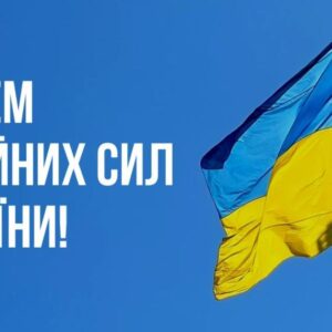 На зображенні — синьо-жовтий прапор України, що майорить на щоглі на тлі чистого синього неба. Ліворуч розміщено білий напис: «6 грудня. З Днем Збройних сил України!».