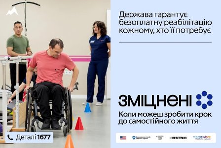 Чоловік на інвалідному візку виконує реабілітаційні вправи в залі під наглядом фахівців. Поруч — реабілітолог і ще один пацієнт. На зображенні розміщено текст: «Держава гарантує безоплатну реабілітацію кожному, хто її потребує», логотип кампанії «Зміцнені» та напис «Коли можеш зробити крок до самостійного життя», внизу — «Деталі 1677».