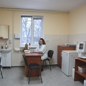 Кабінет Городоцької амбулаторії після поточного ремонту: лікар у білому халаті сидить за робочим столом, у приміщенні встановлено медичне обладнання, мийку, шафи та лабораторні прилади, світле та охайне робоче середовище.