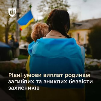 Жінка тримає на руках маленьку дитину, обох огорнуто в синьо-жовтий прапор України. Вони стоять спиною до камери на тлі кладовища з розмитими могилами та державним прапором у далині. На зображенні розміщено напис: «Рівні умови виплат родинам загиблих та зниклих безвісти захисників».