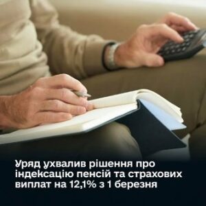 На фото крупним планом зображені руки чоловіка, який сидить на дивані: в одній руці він тримає пульт дистанційного керування, а іншою робить записи в блокноті. Чоловік одягнений у світлий светр. Унизу зображення розміщено текст українською: «Уряд ухвалив рішення про індексацію пенсій та страхових виплат на 12,1% з 1 березня».