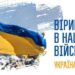 Український синьо-жовтий прапор майорить на вітрі над площею з людьми на задньому плані. Праворуч розміщений напис: «Віримо в наших військових. Україна переможе».