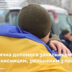 Людина в жовто-синій накидці обіймає військового на вулиці під час холодної погоди.