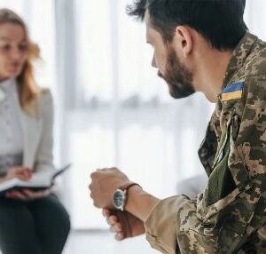 Військовослужбовець у формі спілкується з психологом під час консультації в кабінеті.