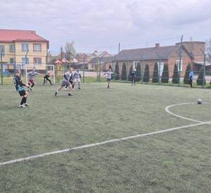 На фото зображено аматорський футбольний матч на відкритому майданчику зі штучним покриттям.