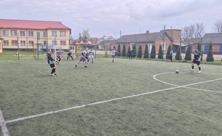 На фото зображено аматорський футбольний матч на відкритому майданчику зі штучним покриттям.