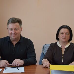 Двоє посадовців сидять за столом під час засідання в кабінеті.