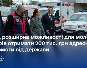 На зображенні представники уряду та медичних служб оглядають автомобілі екстреної медичної допомоги.
