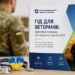 На передньому плані на столі розміщені стетоскоп і синьо-жовте серце з кардіограмою. Поруч стоїть інформаційний буклет Національної служби здоров’я України «Гід для ветеранів: простими словами про медичні гарантії 2026».