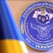 Емблема Координаційного штабу з питань поводження з військовополоненими України на синьому тлі.