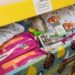 Відкрита коробка «Пакунок малюка» з товарами для новонародженого: підгузками, дитячим одягом, засобами гігієни, іграшками та іншими необхідними речами.