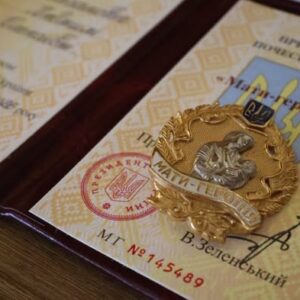 Посвідчення до почесного звання «Мати-героїня» та нагрудний знак «Мати-героїня», розміщені на столі.