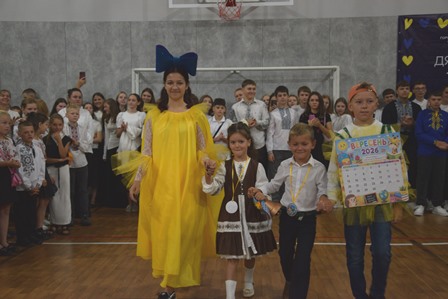 Першокласники разом зі старшокласницею у святковій залі школи під час урочистостей з нагоди Дня знань.