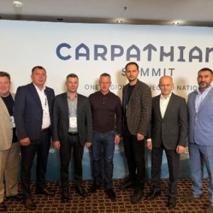 Групове фото учасників міжнародного саміту «Карпатська вісімка C8» на тлі брендованого банера заходу.